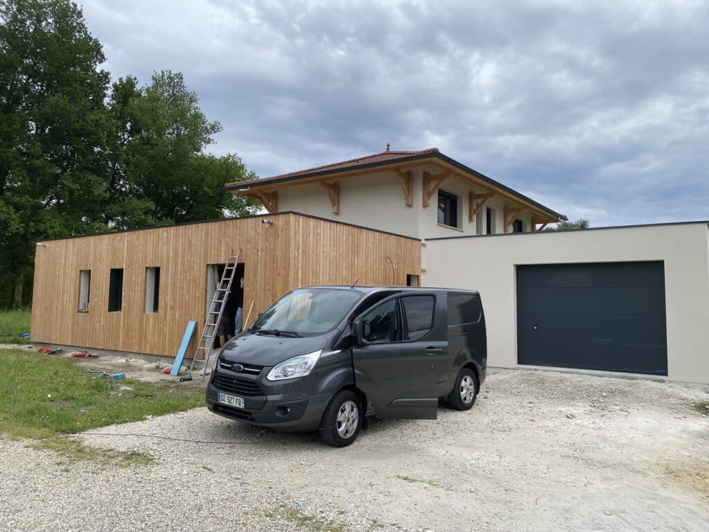 Maison Moderne : Construction Bardage Bois et Garage Extension de maison en bois et garage avec fourgon Ford immatriculé DZ-627-FD sur un chantier de construction.