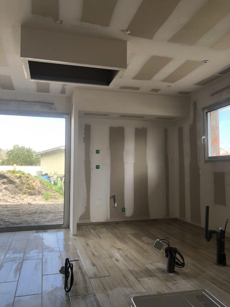 Rénovation cuisine : pose de placo et carrelage imitation bois Chantier de rénovation intérieure : murs en placo, carrelage imitation parquet et installations électriques au sol.