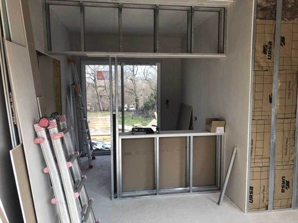 Travaux de rénovation : ossature métallique et isolation URSA Cloisons en plaques de plâtre sur rails métalliques et isolant URSA dans une maison en cours de rénovation.